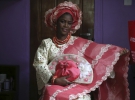 Нигерия. Нигерийские невесты выделяются яркими кружевными блузками и узорчатыми кафтанами, которые часто шьют из индийских тканей. Коралловые бусы и головной убор довершают образ.