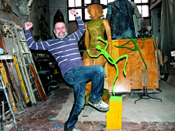 Олександр Рідний у своїй майстерні біля дерев'яної фігури "Большая Мадлен". Автор копіює скульптуру з серії "Танцующие человечки"