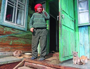 70-річна Галина Безощенко на ґанку власної хати в селі Паришів, за 18 кілометрів від Чорнобиля. Після аварії жінка повернулася додому