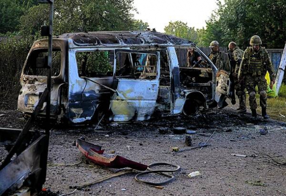 Солдати добровольчого батальйону ”Донбас” оглядають автобус, спалений у боях, що тривали у східній частині міста Іловайськ. 24 серпня 2014 року
