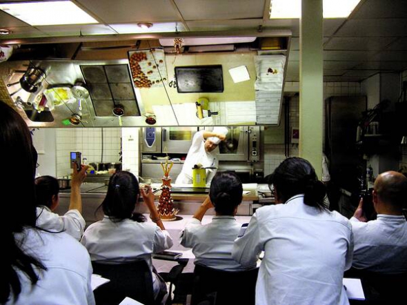 Студенти дивляться майстер-клас кондитера в кулінарній школі Le Cordon Bleu. Вгорі дзеркальна поверхня, щоб було видно все, що робить викладач