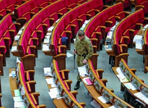 Працівник Служби безпеки України перевіряє сесійну залу перед початком вечірнього засідання Верховної Ради 12 травня. Чекають на приїзд президента Петра Порошенка. Тому ввели додаткові заходи безпеки. На час обшуку зали депутатів вивели