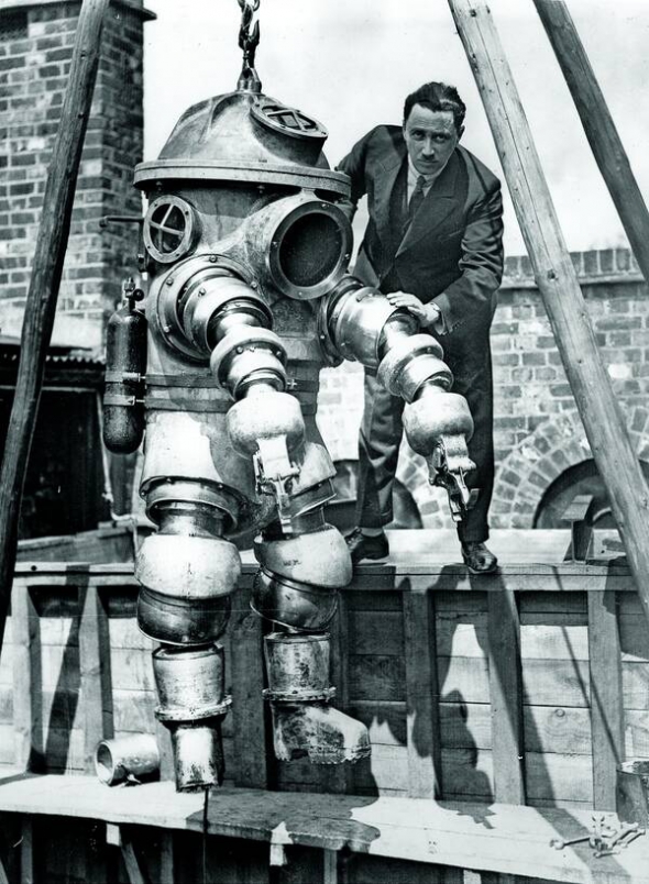28 травня 1930 року розробник моделі водолазного скафандра Джозеф Салім Пересс (1896–1978) тестує винахід у баку з водою, Вейбридж, Велика Британія