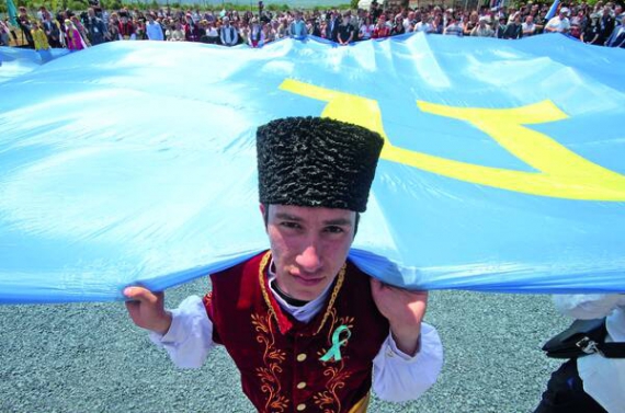 Кримський татарин тримає прапор свого народу на мітингу в Києві 18 ­травня. Стяг завдовжки 10 метрів. Його зшили в Туреччині