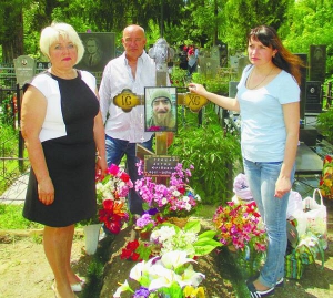 Тетяна Грицай (ліворуч) із чоловіком Юрієм і донькою Юлією стоять біля могили сина Антона на Алеї героїв у Полтаві