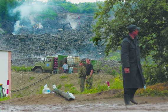 Рятувальники оглядають тліюче звалище. Загиблих колег шукали понад добу. Троє пожежників лежали поруч унизу смітника