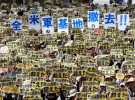 Надпись на плакатах, которые держат протестующие на Окинаве, гласит: "Наше возмущение достигло предела"