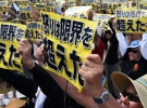 Надпись на плакатах, которые держат протестующие на Окинаве, гласит: "Наше возмущение достигло предела"