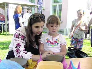 Відвідувачі Націо­нального фестивалю гончарства на майстер-класі з розпису глиняного посуду