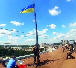 Українські військові підіймають синьо-жовтий прапор над міськрадою визволеного від бойовиків Слов’янська 5 липня 2014 року