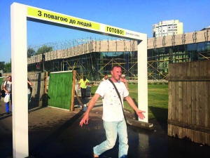Чоловік проходить під рамкою ”Водяна завіса” на площі Лесі Українки у Києві. Воду над перехожими розпилює автомат. Він реагує на рух