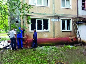 Чоловіки оглядають стіну зруйнованого будинку на вулиці Шашуріна у Горлівці на Донеччині 27 липня. Кілька будинків району Курганка пошкоджені вибуховою хвилею