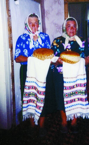 Хресні матері нареченого та нареченої з хлібами йдуть на весілля в селі Мельники-Річицькі Ратнівського району Волинської області, 2002 рік