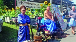 Переодягнені в козаків чоловіки виготовляють пам’ятні монети на Сорочинському ярмарку. Перед продажем молотом наносять зображення гербів. За виріб беруть 40 гривень