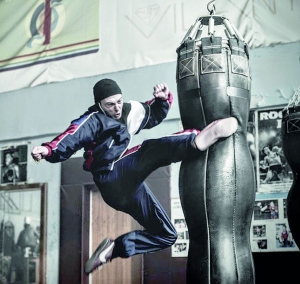 Актор масовки б’є ногою боксерську грушу під час зйомок бойових сцен у фільмі ”Правило бою”