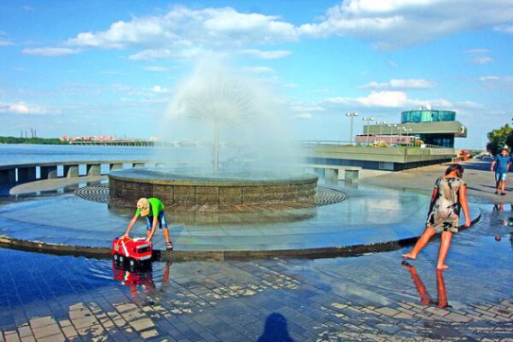 Люди купаються біля фонтану на Січеславській набережній у Дніпрі. Це — улюблене місце для вечірніх прогулянок