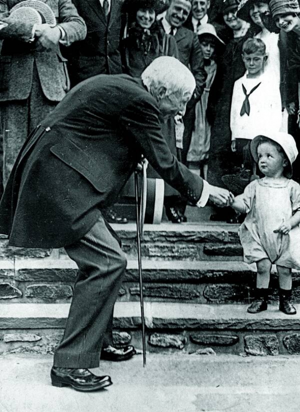 Нафтовий магнат Джон Рокфеллер дає милостиню дитині, початок ХХ століття. 1916 року він став першим у світі мільярдером