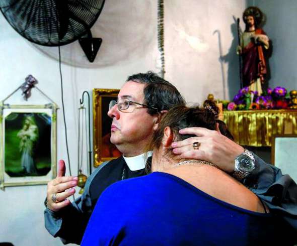 Настоятель аргентинської Лютеранської церкви Мануель Акуна втішає вірянку у своїй церкві в передмісті Буенос-Айреса