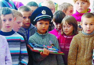 Богдан Івасюк у поліцейській фуражці стоїть серед однокласників. Правоохоронці вручили йому медаль, рюкзак і канцелярські приладдя — за допомогу органам