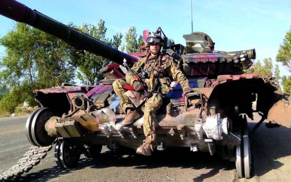 Доброволець ”Азова” Олесь Кромпляс сидить на танку на блокпосту ”Східний” під Маріуполем у вересні 2014 року