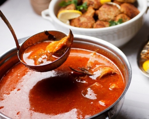 В рыбный суп с томатной пастой добавляют чеснок и паприку