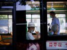 Людей в масках для обличчя в автобусі у місті Ухань, провінція Хубей.