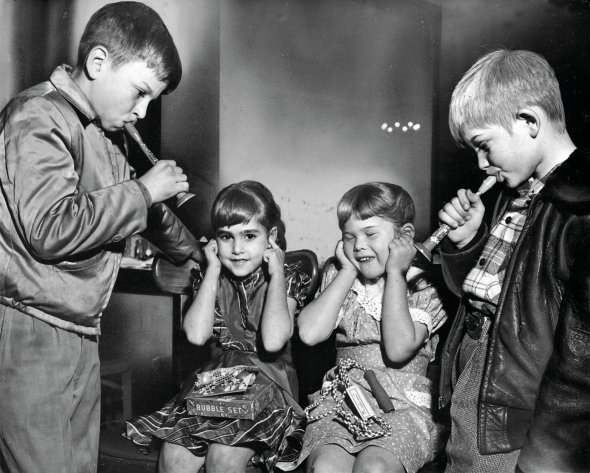 9-річний Ленс і Гарі, 8 років, із Лос-Анджелеського притулку грають на дудках для 6-річних Лінди та Конні 21 грудня 1951-го. Діти беруть участь у щорічній вечірці сиріт, яку влаштовує молодіжна торгова палата Сполучених Штатів Америки