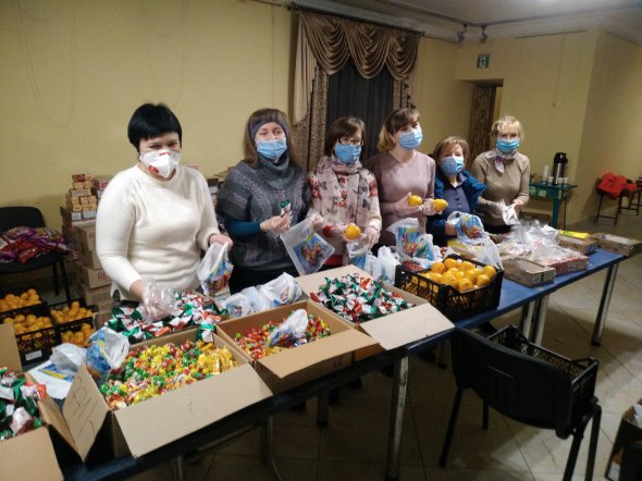 Волонтерка Оксана Четверикова (ліворуч) та її колеги у п'ятницю 18 грудня пакують солодкі подарунки для дітей