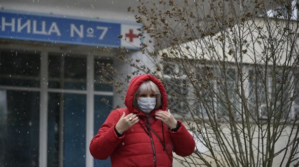 Крымчанка в маске выходит из здания больницы