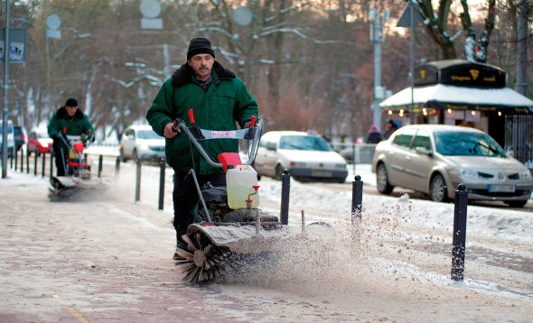 Комунальники прибирають сніг і лід із тротуару у Львові 15 січня. Того дня температура в Україні знизилася до мінус 20 градусів