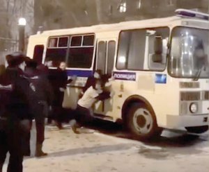 Затримані прихильники Олексія Навального штовхають поліцейський автобус, що не змогли завести, біля Симоновського райсуду в Москві 4 лютого. Протестувальники усміхаються і жартують. Правоохоронці стоять поряд. Затриманих везуть у спецприймальник за 137 кілометрів від столиці 