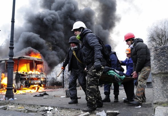 Протестующие помогают пострадавшим во время столкновений с силами "Беркута" 20 февраля 2014 года в Киеве.