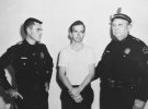 Двое полицейских Далласа держат Ли Харви Освальда после его ареста 22 ноября 1963 года