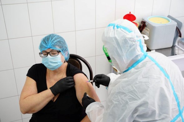 Лікарка отримує першу дозу препарату Covishield у центральній районній лікарні Броварів неподалік Києва 24 лютого 2021 року. Вакцину виготовляють в Індії за ліцензією Oxford/AstraZeneca. Пів мільйона доз напередодні прибули в Україну