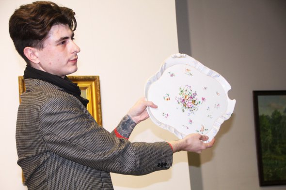 Науковий співробітник музею Назар Майстренко демонструє блюдо, виготовлене в мануфактурі Міклашевського