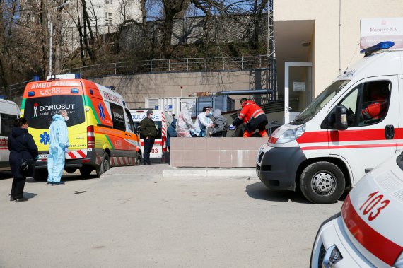 Медичні працівники надають допомогу хворому на вході до лікарні, де лежать пацієнти з коронавірусною хворобою COVID-19