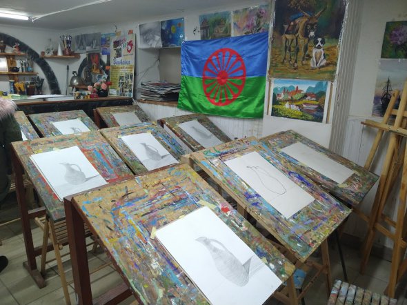 На стінах майстерні художньої школи  Rom Art висять роботи учнів та ромський прапор. Його затвердили на Всесвітньому конгресі ромів у Лондоні 8 квітня 1971 року