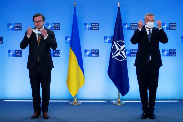 Генеральний секретар НАТО Єнс Столтенберг та міністр закордонних справ України Дмитро Кулеба знімають захисні маски для обличчя до офіційного привітання в штаб-квартирі НАТО в Брюсселі, Бельгія, 13 квітня 2021 року.