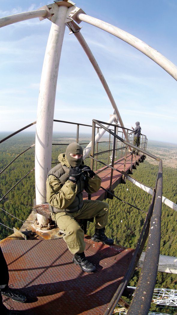 Дмитро Науменко сидить на щоглі радіолокаційної станції ”Дуга-2” в Чорнобилі. Тут сталкери люблять зустрічати світанок чи  дивитися на захід сонця
