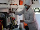 Лаборант берет на анализ смывы с поверхностей в медицинском автомобиле перед обработкой
