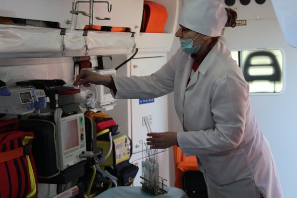 Лаборант бере для аналізу змиви з поверхонь в медичному автомобілі перед обробкою