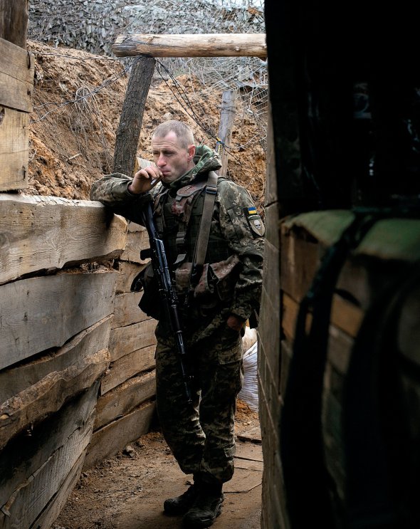Український військовий  курить в окопі на лінії розмежування поблизу Донецька 15 квітня 2021 року