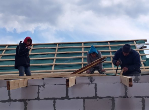 Мужчины семьи самостоятельно пытаются восстановить крышу дома