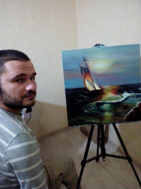 Художник Федор Романов пишет картины, держа кисть зубами.