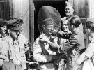 Немецкому солдату надевают маску от комаров на Кубани. 1943