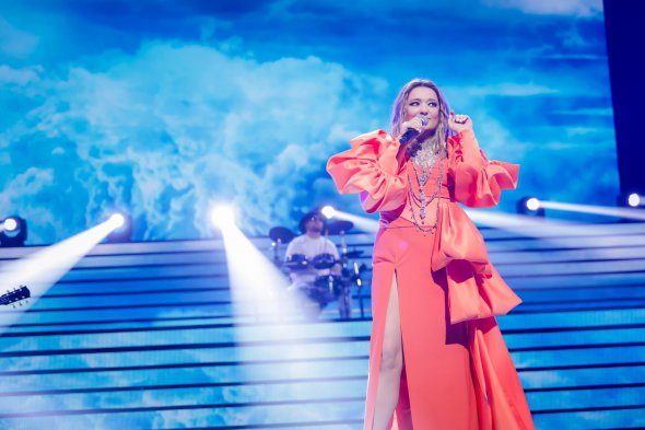 Наталя Могилевська з'явилася на сцені в ефектній помаранчевій сукні з глибоким декольте і високим прорізом. Образ доповнювали масивні прикраси. Співачку винагородили за пісню «Відірватись від землі»