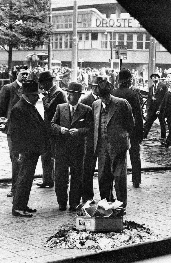 Чоловіки стоять на місці вбивства провідника Організації українських націоналістів Євгена Коновальця. Йому в коробку з цукерками підклав вибухівку агент радянських спецслужб Павло Судоплатов, Нідерланди, місто Роттердам, 23 травня 1938 року