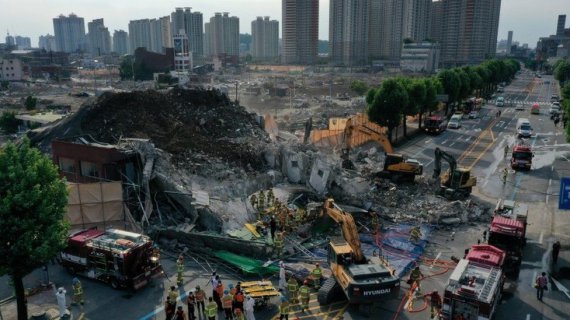 Южнокорейские пожарные ищут пассажиров автобуса, который застрял под обломками разрушенного здания в Кванджу, 9 июня 2021-го / Reuters