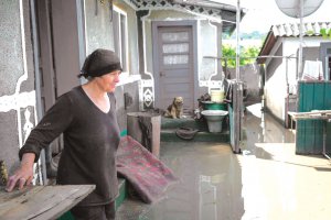 Жінка стоїть на затопленому подвір’ї в селі Вікно Чернівецького району на Буковині. Воно — одне з найбільш постраждалих від потопу 20 червня. Із присадибних ділянок, господарств і житлових будинків рятувальники відкачували воду мотопомпами