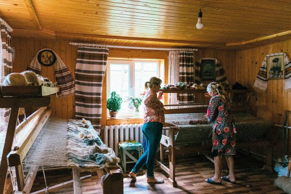 Ганна Копильчук тче ліжники на верстаті вдома у майтерні. Їй допомагає донька